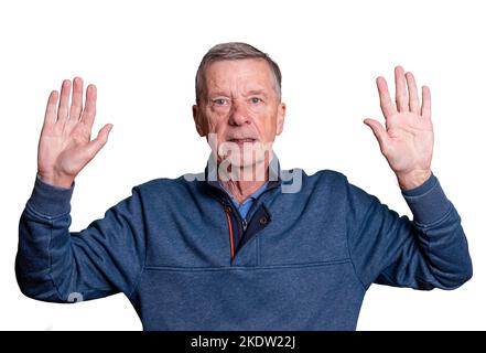 Älterer erwachsener Mann mit erhobenen Händen und besorgtem Ausdruck, als er sich seinem Schicksal hingibt Stockfoto