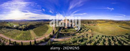 Goldene Weinberge der Toskana. Luftdrohnenansicht, Panorama der mittelalterlichen Burg - Castello di Banfi. Italien, Toscana Landschaft Hochwinkel Panoramablick Stockfoto