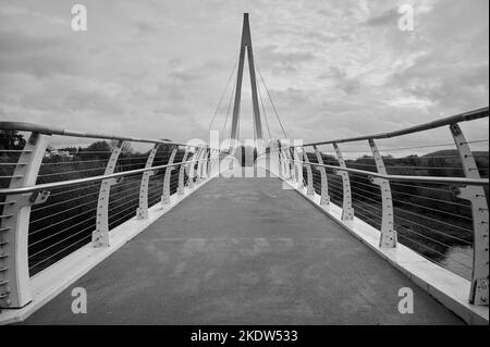 07 Nov 2022 - Hereford / UK: Schwarz-weiß-monochrome Darstellung der Greenway Bridge , einer Fußgängerbrücke in Hereford, Großbritannien, an bewölktem Tag Stockfoto