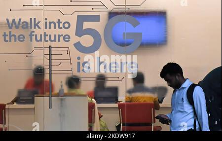 Mumbai, Maharashtra, Indien. 8.. November 2022. Ein Mann überprüft sein Mobiltelefon, während er an einer 5G-Anzeige vorbeigeht, die an der Tür eines Mobilfunkanbieters in Mumbai steht. 5G ist die fünfte Generation der Mobilfunktechnologie, hundertmal schneller als 4G, was dazu beitragen wird, Chancen für Menschen und Unternehmen zu schaffen. (Bild: © Ashish Vaishnav/SOPA Images via ZUMA Press Wire) Bild: ZUMA Press, Inc./Alamy Live News Stockfoto