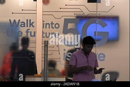 Mumbai, Maharashtra, Indien. 8.. November 2022. Ein Mann überprüft sein Mobiltelefon, als er aus einem Geschäft eines Mobilfunkanbieters geht, in dem 5G-Service in Mumbai angeboten wird. 5G ist die fünfte Generation der Mobilfunktechnologie, hundertmal schneller als 4G, was dazu beitragen wird, Chancen für Menschen und Unternehmen zu schaffen. (Bild: © Ashish Vaishnav/SOPA Images via ZUMA Press Wire) Bild: ZUMA Press, Inc./Alamy Live News Stockfoto