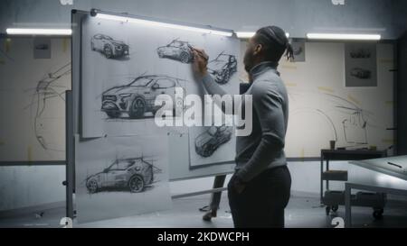 Zwei verschiedene männliche Automobildesigner zeichnen Skizzen mit Markern auf Whiteboards und entwickeln ein futuristisches Elektroauto-Design. Sie arbeiten in einem modernen Entwicklungsstudio für Fahrzeugdesign. Stockfoto