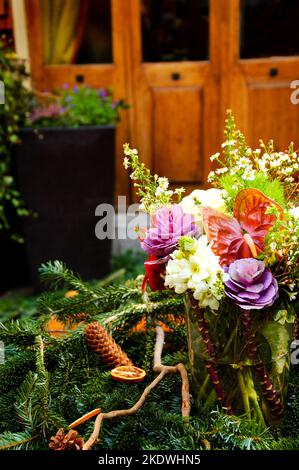 Weihnachtskranz Dekoration auf Terrasse Tisch in der Nähe Haus Tür. Stockfoto