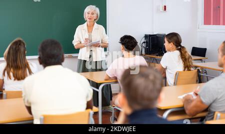 Ältere weibliche Lehrerin, die im Auditorium vor einer Gruppe von Studenten vorspricht Stockfoto