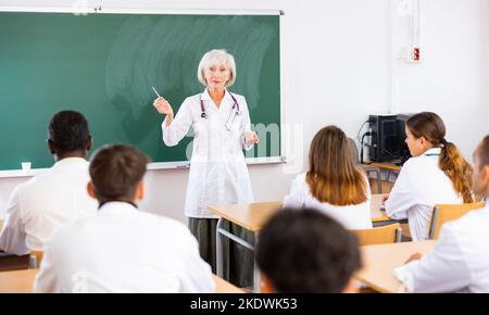 Ältere Professorin für Medizin, die Studenten im Rahmen eines Fachseminars vorspricht Stockfoto