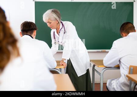 Ältere Professorin für Medizin, die Studenten im Rahmen eines Fachseminars vorspricht Stockfoto