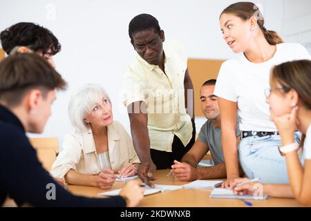 Multirassische gemischte Altersgruppe, die an der Erwachsenenbildungsklasse mit afroamerikanischem Tutor teilnimmt Stockfoto