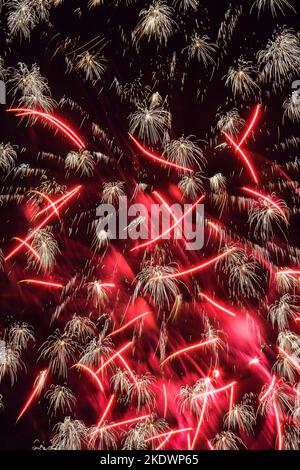 Rot-weißes Feuerwerk am Nachthimmel. Stockfoto