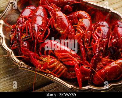 Nahaufnahme. Meeresfrüchte. Rot gekochte Krebse in einer Schüssel auf einem hölzernen Hintergrund. Gesunde Lebensmittel, Proteine, Vitamine. Gerichte der Restaurantküche. Meeresfrüchte-Recip Stockfoto