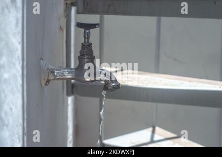 Alte und gebrauchte Vintage Wasserhahn mit Wassertropfen, natürliches Licht. Stockfoto