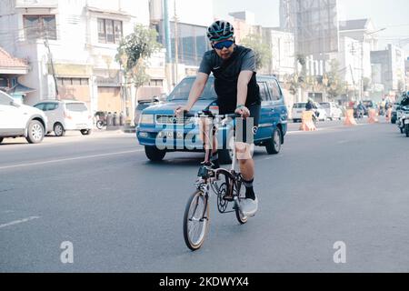 Ein erwachsener Mann radelt in der indonesischen Stadt Malang Stockfoto