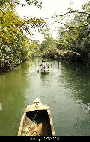 Nationalpark-Ranger, die mit dem Boot auf dem Cigenter River durch den Küstenwald von Handeuleum Island fahren, einem Teil des Ujung Kulon Nationalparks in Pandeglang, Banten, Indonesien. Stockfoto