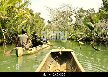 Nationalpark-Ranger, die mit dem Boot durch den Cigenter River auf Handeuleum Island fahren, einem Teil des Ujung Kulon National Park in Pandeglang, Banten, Indonesien. Stockfoto