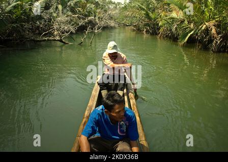 Nationalpark-Ranger, die mit dem Boot auf dem Cigenter River durch den Küstenwald von Handeuleum Island fahren, einem Teil des Ujung Kulon Nationalparks in Pandeglang, Banten, Indonesien. Stockfoto