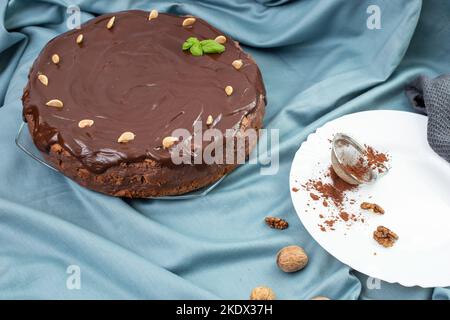 Runder Schokoladenkuchen auf blauem Stoff-Backdop Stockfoto