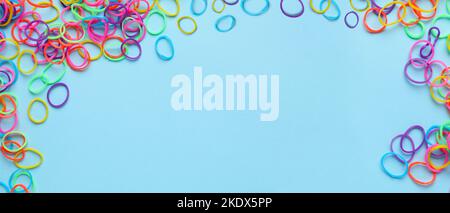 Viele bunte Gummibänder auf hellblauem Hintergrund mit Platz für Text Stockfoto