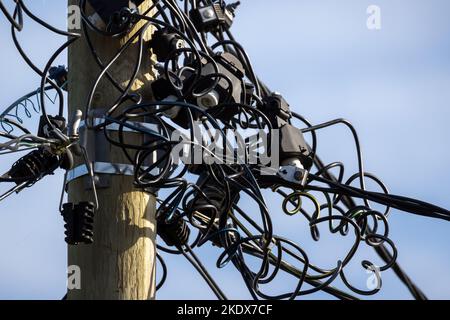 Top of a pole with a lot of power wires is under blue sky Stockfoto