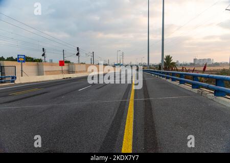 Endlose Straße, keine Menschen, keine Autos. Konzept „Copy Space“. Eine Straße mit einer gelben Bordsteinkante. Eine Spur mit einer durchgehenden Trennlinie. Hochwertige Fotos Stockfoto