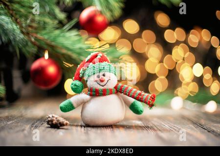 Spielzeug Schneemann auf dem Hintergrund der Weihnachtslichter . Stockfoto
