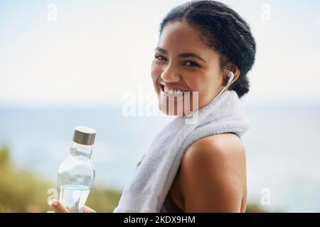 Gesund und fit bleiben mit dem perfekten Soundtrack. Porträt einer sportlichen jungen Frau, die zum Laufen unterwegs ist. Stockfoto