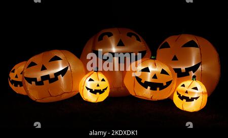 Aufblasbare Kürbisse leuchten im Dunkeln für Halloween-Dekorationen. Stockfoto