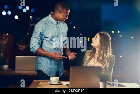 Ich hatte gehofft, dass Sie mir eine Hand geben könnten... zwei junge Kollegen, die spät im Büro zusammen arbeiten. Stockfoto