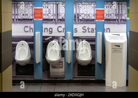 Reihe von Urinalen in Charing Cross Station. Herren-WC im Bahnhof Charing Cross mit detailliertem Foto-Backsplash Stockfoto