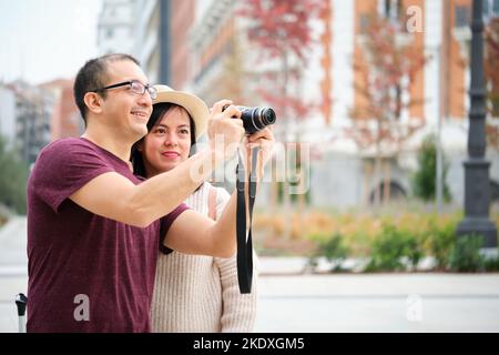 Glückliche multirassische paar Touristen, die Fotos in der Stadt zusammen. Stockfoto