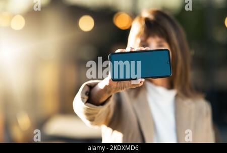 Hände, Geschäftsfrau und Telefon mit grünem Bildschirm für Werbung, Marketing oder Werbung. Mockup Raum, professionelle Dame und Nahaufnahme des Smartphones Stockfoto