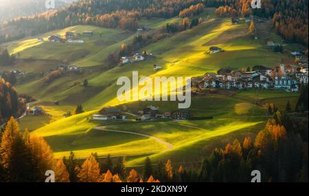 Schönes Bergdorf auf Hügeln bei Sonnenuntergang im Herbst Stockfoto