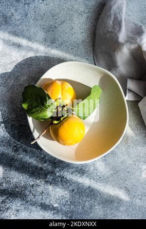 Von oben herbstliche Platzkulisse mit frischen reifen Kaki-Früchten auf Betontisch Stockfoto