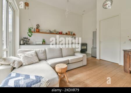 Geräumige Küche mit modernen Geräten und Wohnzimmer mit neuen Möbeln in neuen offenen Raum Wohnung Stockfoto