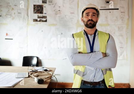 Bauarbeiter, Porträt und Mann mit gekreuzten Armen im Büro oder auf der Baustelle für Architekturprojekt. Architekt, Ingenieur oder seriöser Mann Stockfoto