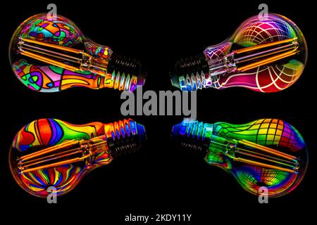 Eine Glühlampe auf schwarzem Hintergrund mit einer hellen Musterspiegelung im Inneren Stockfoto