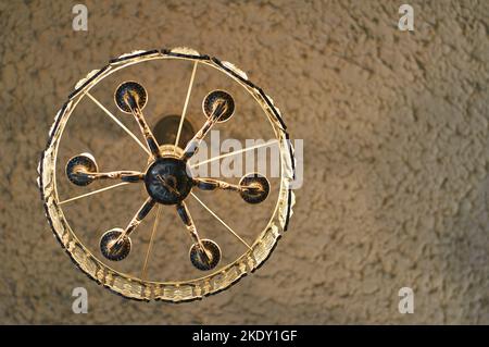 An der Decke hängt ein antiker Kronleuchter. Ansicht von unten. Beleuchtung Stockfoto