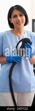 Portrait der Kosmetikerin mit Maschine zur Laser-Haarentfernung im Schönheitssalon Stockfoto