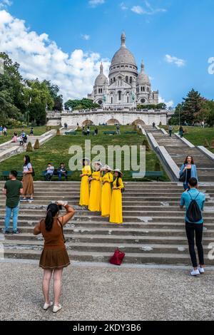 Paris, Frankreich - 09-10-2018: Chinesische Mädchen in traditionellen Kleidern in Paris mit der Basilika Montmartre im Hintergrund Stockfoto