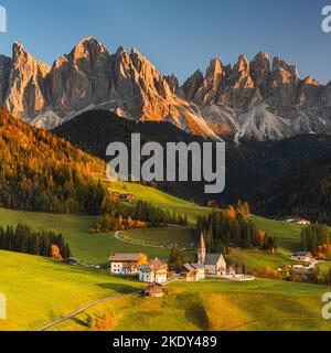 Ein quadratisches Bild von einem herbstlichen Sonnenuntergang an der berühmten Kirche und dem Dorf Santa Maddalena vor den Geisler- oder Geisler-Dolomiten-Gipfeln in V Stockfoto