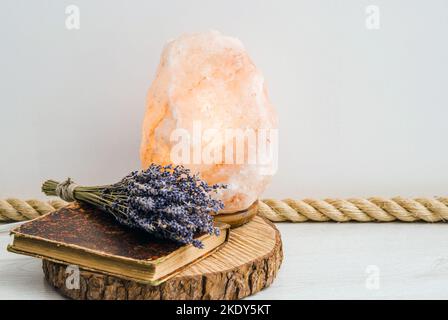 Mit Jute Seil als Bodenverkleidung, boho Home Design-Element. Weißer Wohnzimmerboden mit Jutenseilverkleidung, Holzscheibenablage, Vintage-Buch und getrocknetem Lavendel. Stockfoto