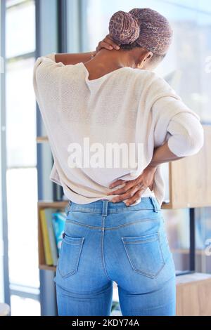 Schwarze Frau, Rücken- und Nackenschmerzen bei Stress, müde oder überfordert von der Arbeit zu Hause. Afroamerikanische Frau, die an Muskelverspannungen, Beschwerden leidet Stockfoto