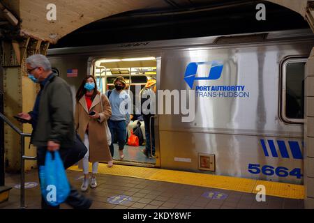 Menschen, die einen Trans Hudson PATH-Zug der Port Authority an der Grove Street Station in Jersey City, New Jersey, verlassen. April 2022. Stockfoto