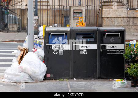 Mülleimer, Recycling-Mülleimer und Müll an einer Straßenecke in New York City. Stockfoto