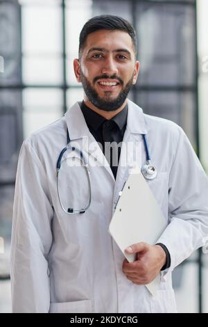 Lächelnd männlichen Arzt mit verschränkten im Krankenhaus Stockfoto