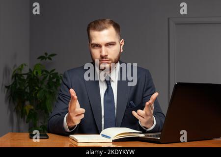 Selbstbewusster erfolgreicher Geschäftsmann in Suit arbeitet in seinem Büro. Multitasking-Konzept Stockfoto