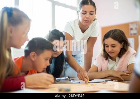 Lehrer und Schüler spielen Brettspiel in der Schule Stockfoto