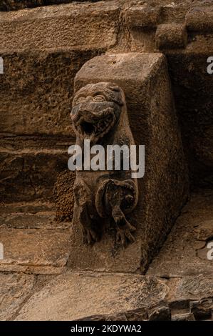 Hundeähnliches Tier mit einem Mund voller scharfer Zähne. Auf einem mittelalterlichen Korbeltisch über dem geformten romanischen Westportal zur ehemaligen königlichen Klosterkirche Santa Maria in Santa Cruz de la Serós in Huesca, Aragon, Spanien. Die Kirche, die erstmals im Jahr 1070 erwähnt wurde, wurde für ein Benediktinerkloster errichtet, das vom Königshaus Aragonien als „Familienkloster“ gegründet wurde. Stockfoto