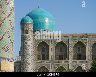 Bögen, Kuppeln und Minarett mit schöner Mosaikdekoration auf dem antiken Tilya Kori madrassa im UNESCO-Weltkulturerbe Samarkand, Usbekistan Stockfoto