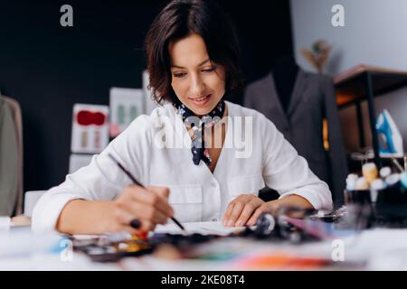 Frau zeichnet Skizzen von Kleidung Stockfoto