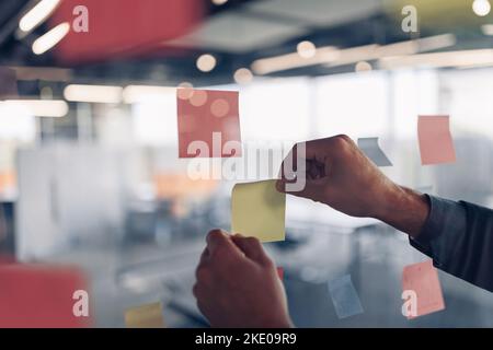 Geschäftsfrau Hand klebt Haftnotizen auf Motivationsbrett im Büro Stockfoto