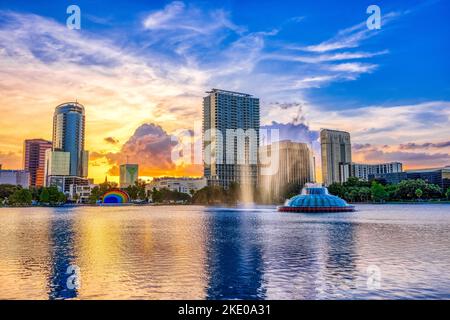 Sonnenuntergang und Wolken über der Skyline von Orlando und dem Brunnen im Lake Eola Park, Orlando FL Stockfoto